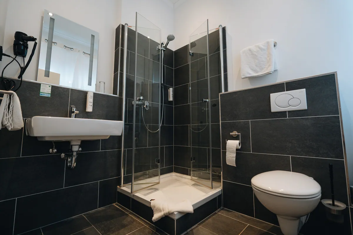 Badezimmer in Schwarz mit ebenerdiger Dusche
