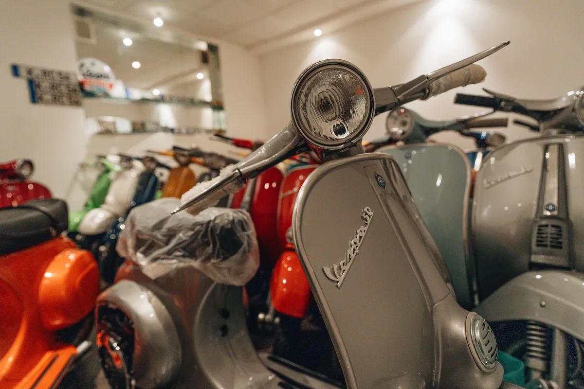 Rote Vespa im Vordergrund der Sammlung