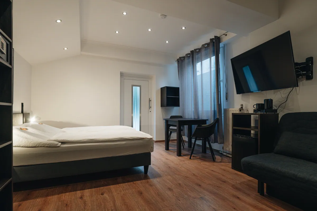 Zimmer mit Doppelbett, Sofa und Fernseher